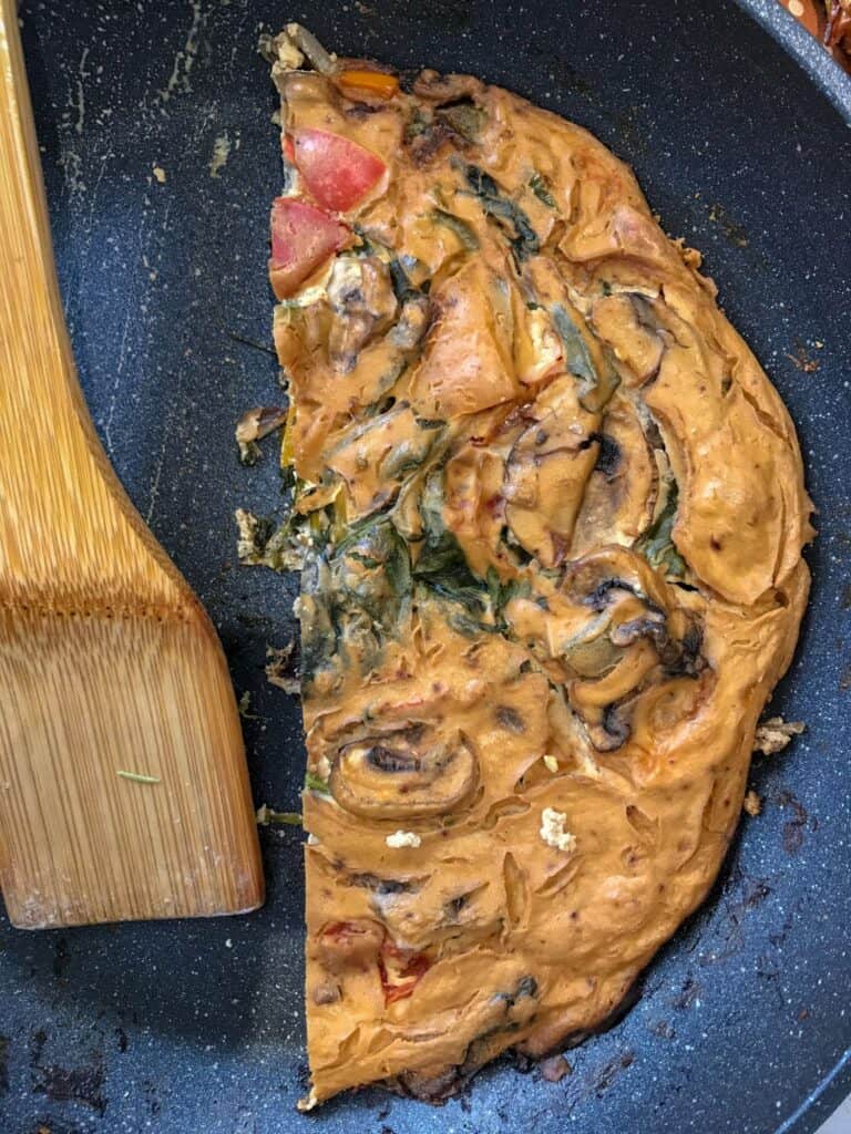 Vegan frittata on pan and wooden spoon